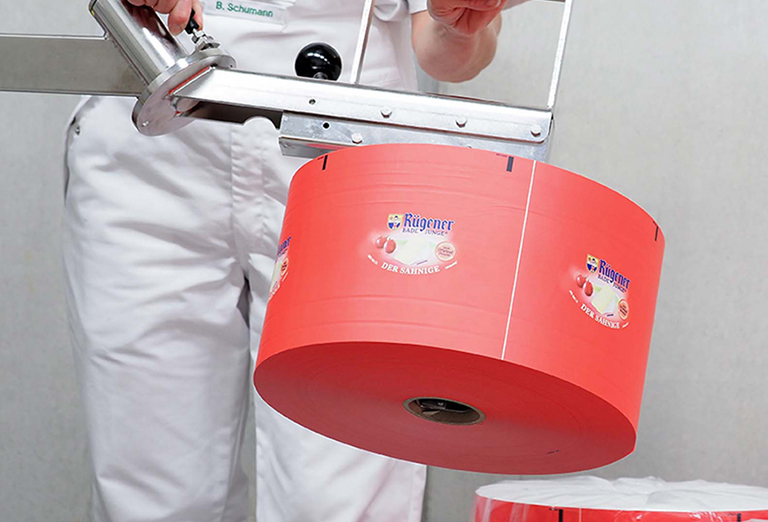 człowiek pracujący przy maszynie z czerwonym dużym elementem